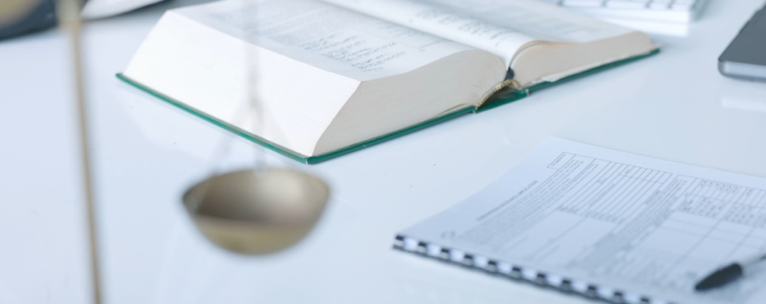 Libro de normativa y documentación de cumplimiento sobre un escritorio